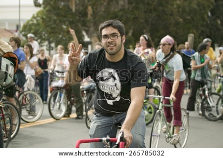 Protesters arrive on bicycle and give the peace sign at an anti-Iraq War protest march in Santa Barbara, California on March 17, 2007