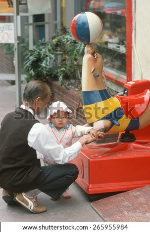 A Chinese man playing with his granddaughter, Chinatown, Los Angeles, CA