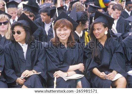 Three graduates smiling during their ceremony, UCLA, Los Angeles, CA