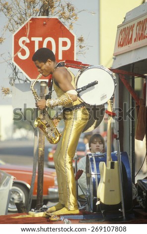 A one-man band in a gold lame costume performing on the street, Venice, CA