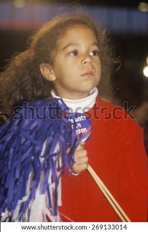 Little girl holds pom pom at a Denver campaign rally in 1992, Bill Clinton\'s final day of campaigning in Denver, Colorado