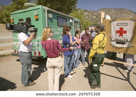 Media crews and forest service personnel meet with locals during Ventura County\'s Day Fire of 2006