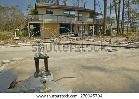 Baseball trophy and debris in front of house heavily hit by Hurricane Ivan in Pensacola Florida