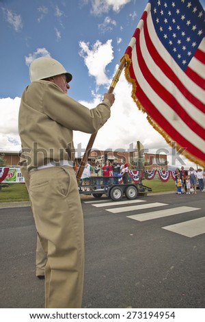 Member of a color guard carrying an American flag, in Lima Montana