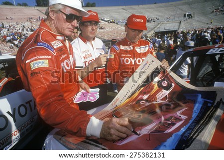 Three drivers sign posters at an off-road truck racing event at the Rose Bowl in Pasadena, California, ca. 1993