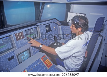 A boy attending space camp at the George C. Marshall Space Flight Center in Huntsville, Alabama, sits in the cockpit of a space shuttle flight simulator