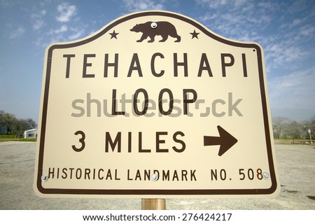 A sign Tehachapi Train Loop, Tehachapi California is the historic location of the Southern Pacific Railroad where freight trains gain 77 feet in elevation and show freight cars traveling in giant loop