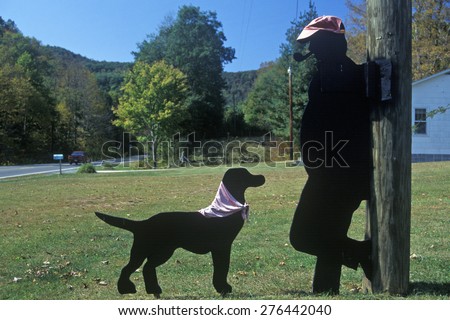 Black dog and man smoking pipe wooden cutouts by roadside, Route 39, WV