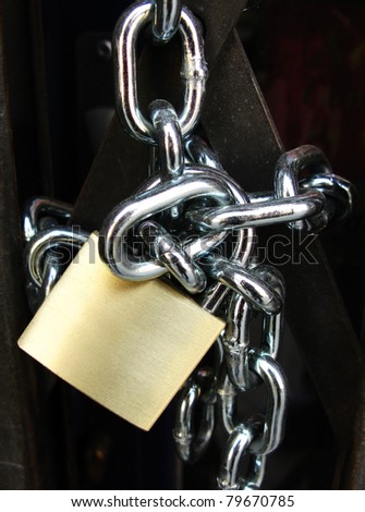 Key lock locked with a chain, in black background