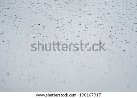 Raindrops on window, clouds as a background