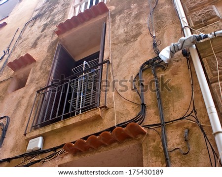 Old wall with window, clothes dryer and old cables on it