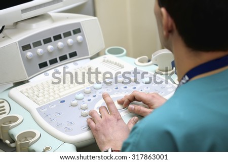 Doctor\'s hand doing medical examination of patient with ultra sound scanner machine