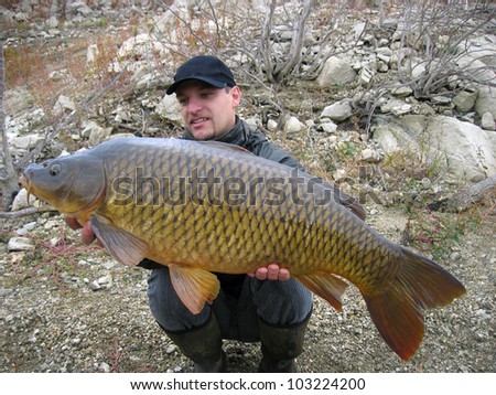 Lucky fisherman holding a beautiful common carp