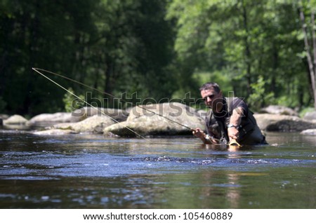 Dry fly fishing. Fly fishermen in a French trout river. Fisherman fight against a big trout