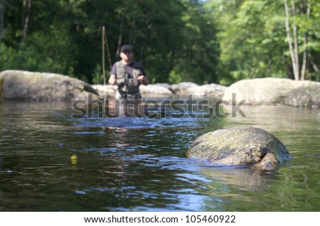 Dry fly fishing. Fly fishermen in a French trout river. Fishing scene focused on fly fishing lure