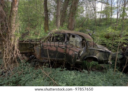 Abandoned rusty car in the forest