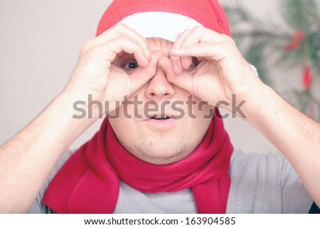 santa looking through binoculars among the branches of trees