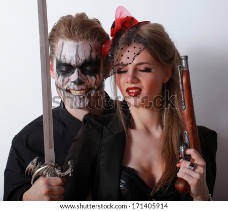 Couple with a dark skull makeup man on a gray background. Halloween face art