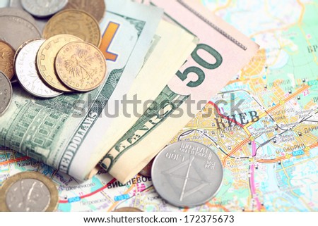 cash dollars and coins on the map