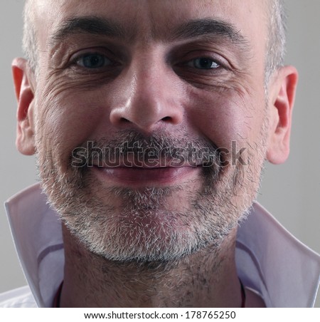 adult thin unshaven gray-haired man in a white shirt emotional