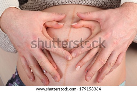 Pregnant woman holding hands on her stomach