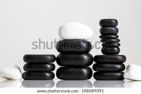 Black massage stones on white background
