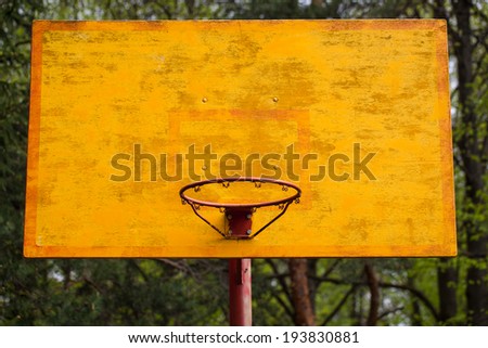 yellow basketball backboard with a ring in the park
