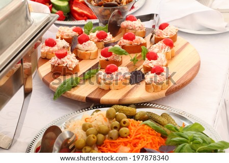 outdoor buffet with salads, appetizers, pickles, sandwiches