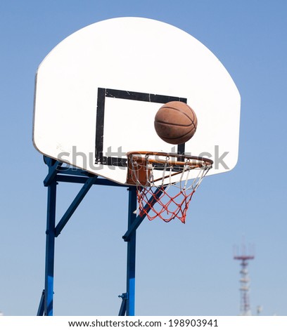 Ring and ball on background of the sky and the city.Basketball in Flight