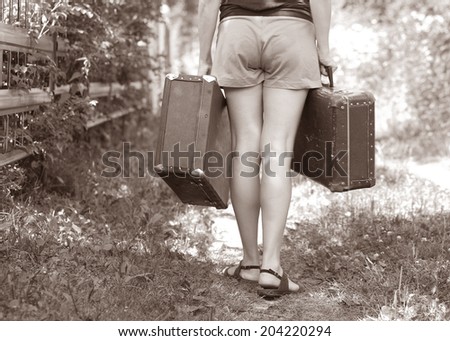retro bags in hands of the girl. woman brings two suitcases