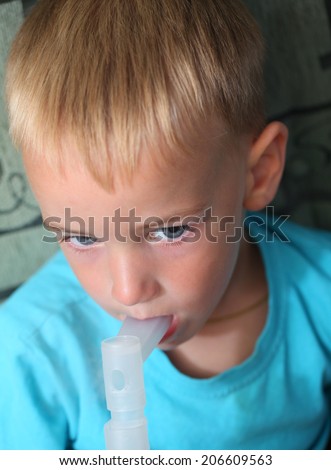 boy makes inhalation from cough and runny nose at home