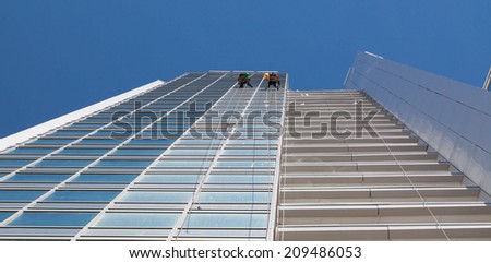 industrial climbers clean windows of high-rise buildings