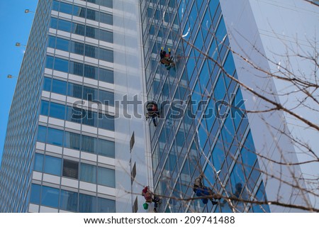 industrial climbers clean windows of high-rise buildings