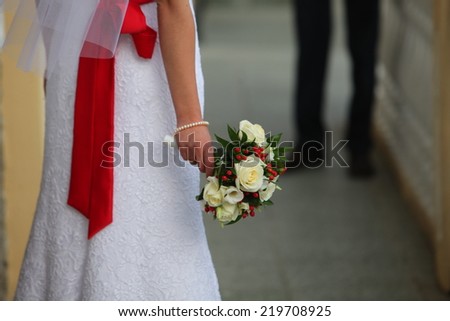 bouquet of flowers in the bride\'s hands rear view