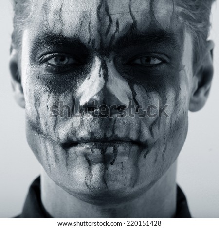 Portrait of serious man with Halloween skull makeup. Halloween or horror theme