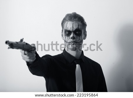 Portrait of serious man with Halloween skull makeup. Halloween or horror theme.