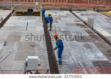 Renaissance construction workers reinforce fitting. The concrete foundation of the hotel building. Belarus,Minsk,November,1,2014
