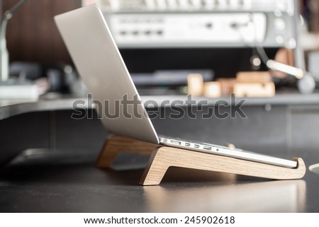 The laptop is on the table. Computer on a wooden stand.