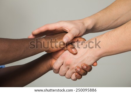 four hands shaking European African friends
