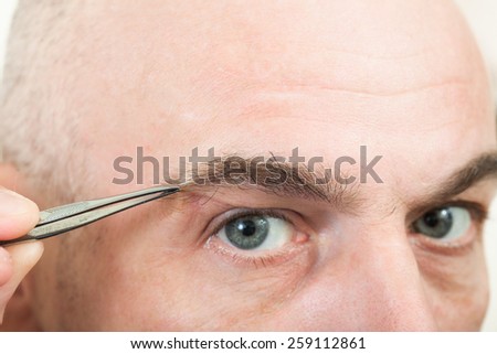 man plucking eyebrows