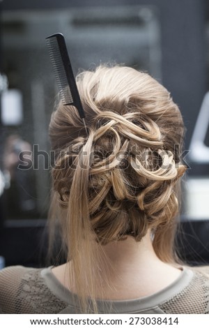 Creative creation of women\'s wedding hairstyle rear view comb hair. Beauty salon mirror interior.