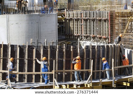 construction of a shopping complex. Monolithic concrete structure during construction trade workers in uniform. Reinforcement and formwork workers.  Belarus, Minsk, April 13 , 2015