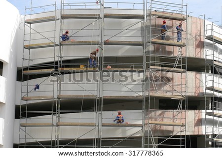 construction workers at the height of the wall plaster. Belarus, Minsk, 13 September 2015