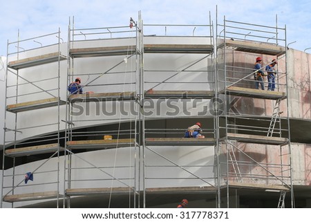 construction workers at the height of the wall plaster. Belarus, Minsk, 13 September 2015