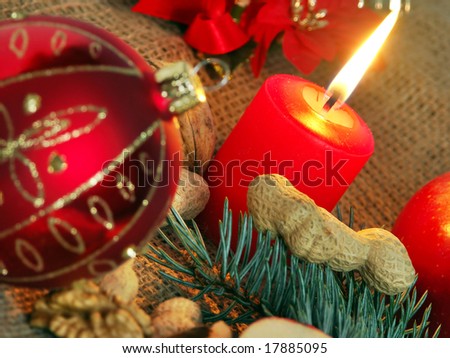 Christmas still life in red candle and dry fruit