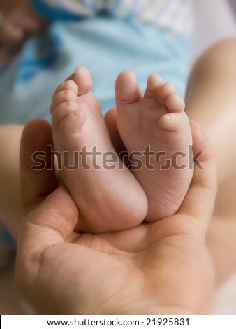 soft holding her child\'s little feet