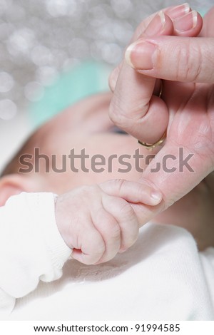 mother touch hand with newborn