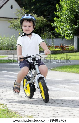 Baby boy on traffic playground for childs with crash helmet