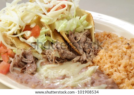 Tacos / A plate of Shredded meat tacos. served with rice and meat.