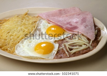 breakfast eggs / Two sunny side up eggs served with ham,  beans, and hash brown.
